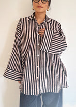 Load image into Gallery viewer, Front view of model wearing the Signature Big Shirt in black stripe, showing oversized sleeves and block-printed cotton

