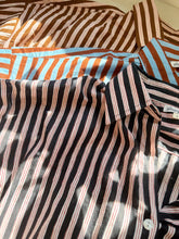 Load image into Gallery viewer, Vertical closeup of the Signature Big Shirt in black stripe, brown stripe, and blue and brown stripe, showing the block-printed cotton shirts
