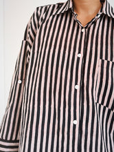 Load image into Gallery viewer, Closeup of model wearing the Signature Big Shirt in black stripe, showing button down block-printed cotton and buttons on oversized sleeves

